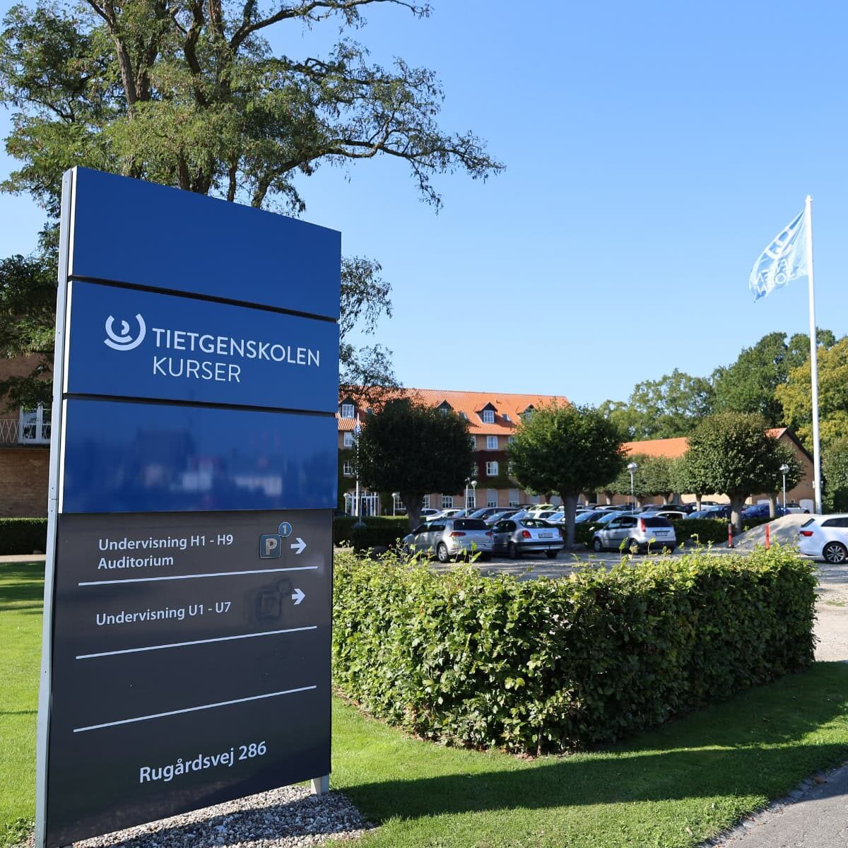 Pylon med vejvisning, der står foran TietgenSkolen Kurser